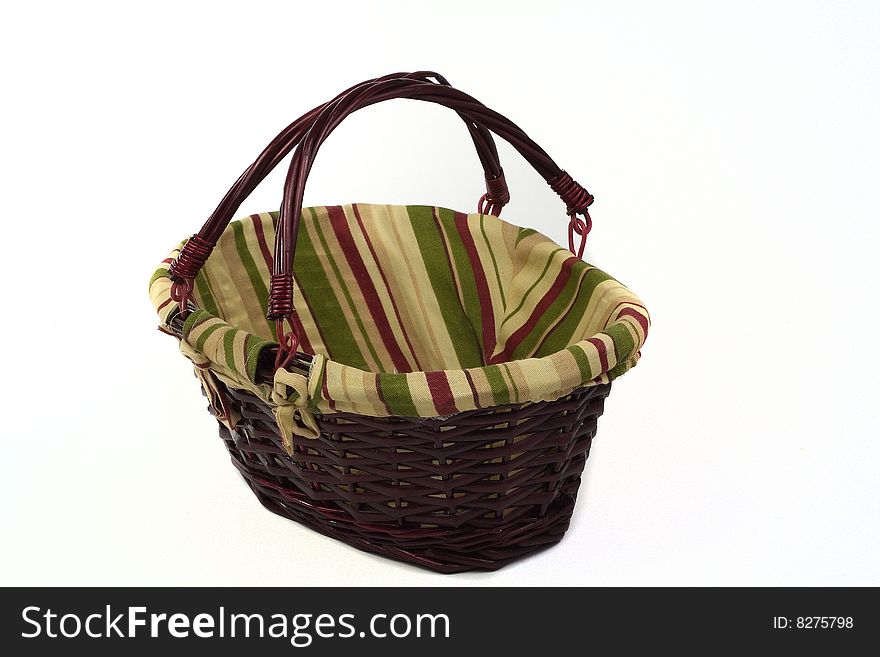 Cane basket with stripped cloth and handles isolated on white background. Cane basket with stripped cloth and handles isolated on white background