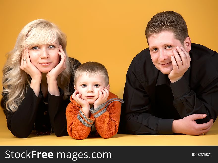 Happy family with baby on yellow background. Happy family with baby on yellow background