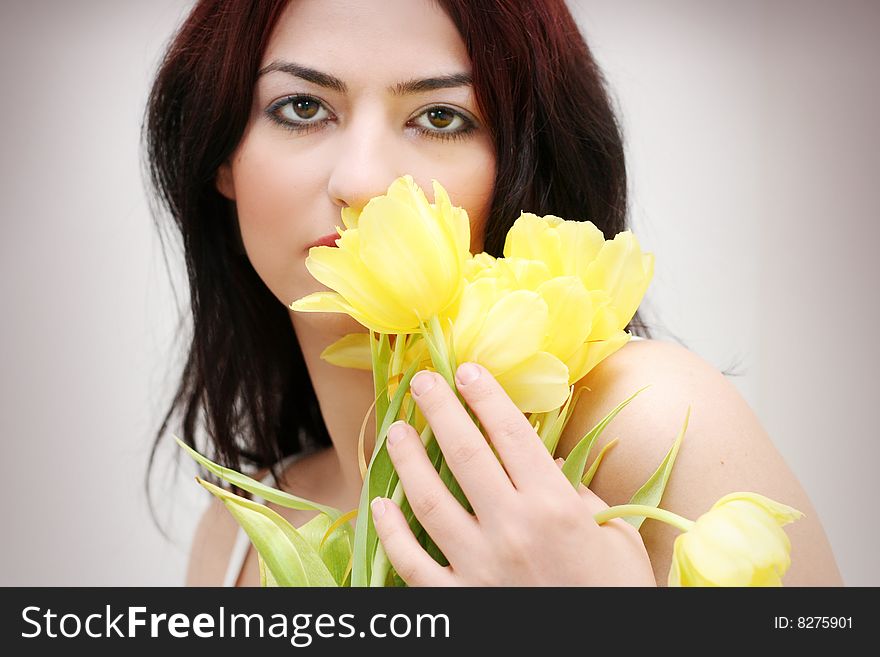 Oriental pretty girl with yellow tulips. Oriental pretty girl with yellow tulips