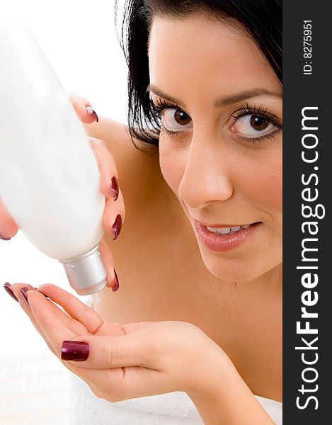 Close up of young woman taking lotion in hand on an isolated white background. Close up of young woman taking lotion in hand on an isolated white background