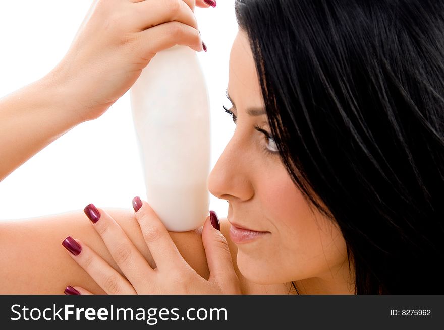 Portrait of young woman holding lotion bottle with white background