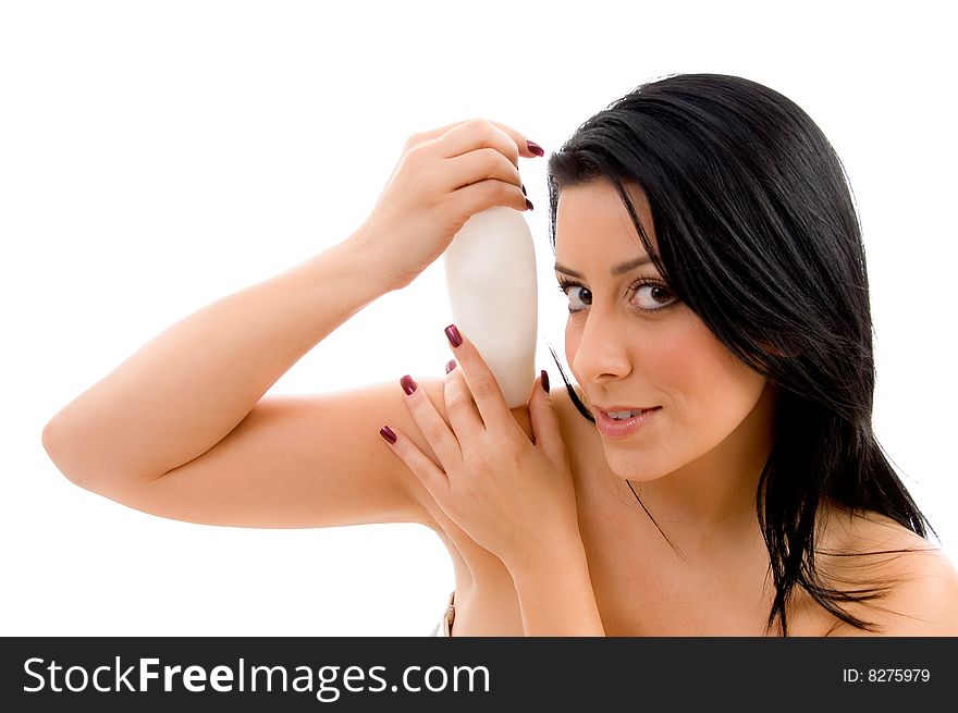 Portrait of young female holding lotion bottle against white background. Portrait of young female holding lotion bottle against white background