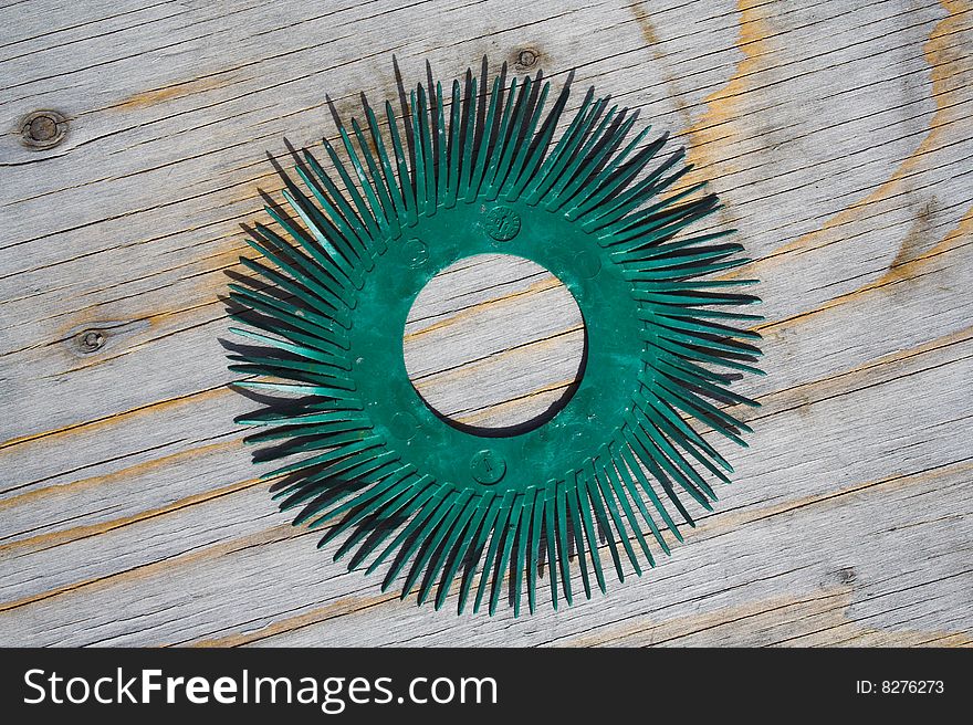 Green plastic circle with pins on wooden background