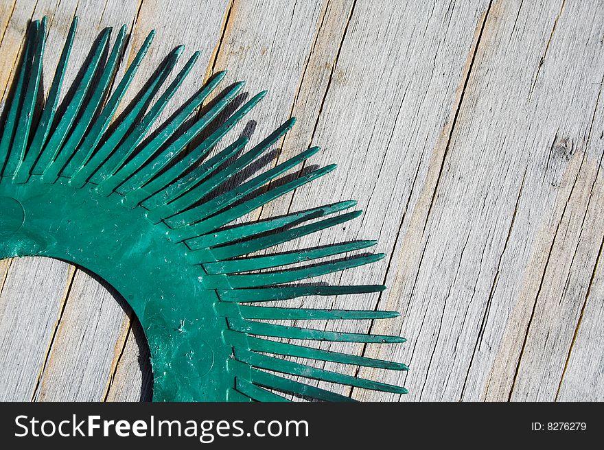 Closeup of Green plastic circle with pins on wooden background. Closeup of Green plastic circle with pins on wooden background