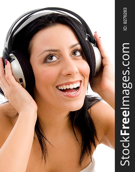 Front view of smiling young female enjoying music against white background. Front view of smiling young female enjoying music against white background