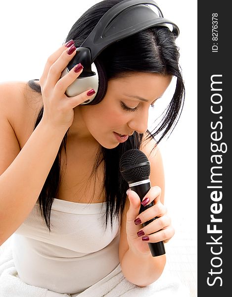 Top view of young female holding headphone and microphone against white background