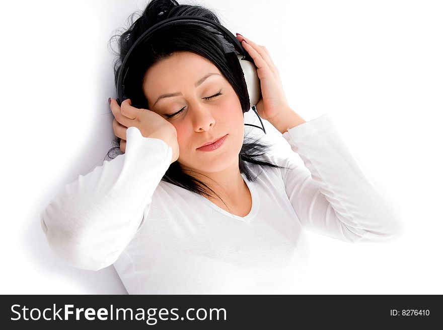 Top view of laying young woman enjoying music against white background. Top view of laying young woman enjoying music against white background