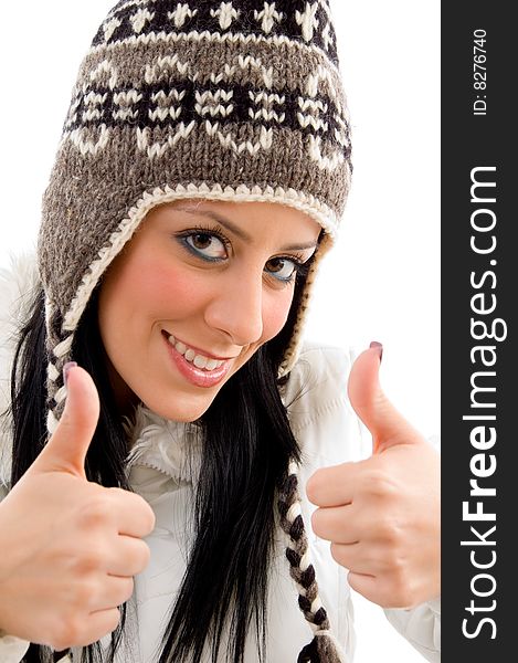 Front view of smiling woman with woolen cap and thumbs up on an isolated white background