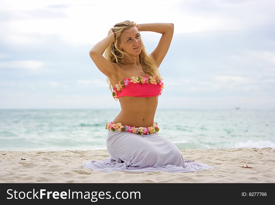 Blonde girl sitting on the sandy beach. Blonde girl sitting on the sandy beach