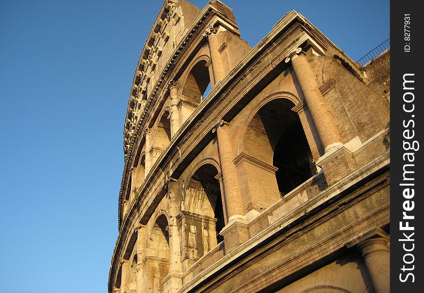 Side view of the Colosseum with blue sky background. Side view of the Colosseum with blue sky background