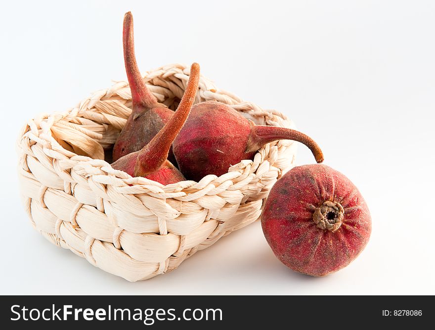 Still life of four fresh figs in a woven straw basket on white background. Still life of four fresh figs in a woven straw basket on white background