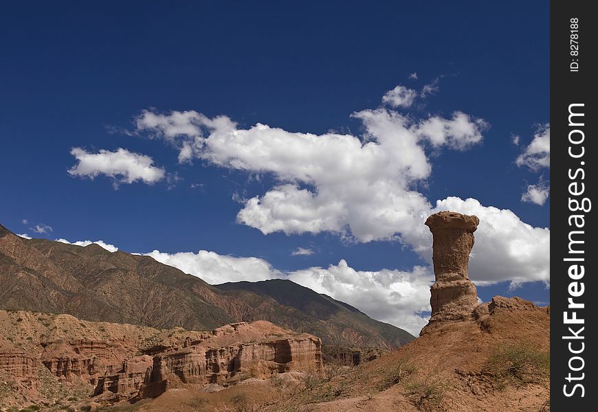 A remote desert landscape with a large sandstone structure formation.