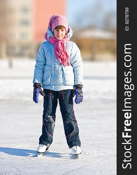 Girl on skates at the skating rink in winter.