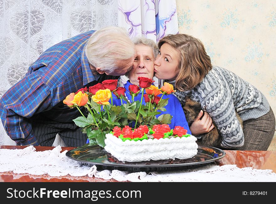 Granddaughter and grandfather kissing grandmother. Granddaughter and grandfather kissing grandmother