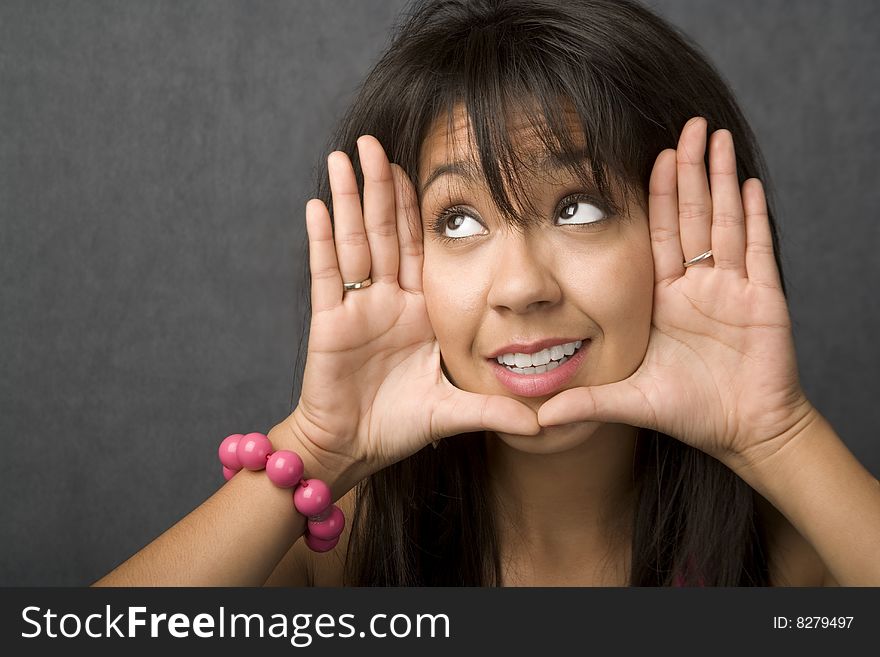 Beautiful young woman framing her face with hands