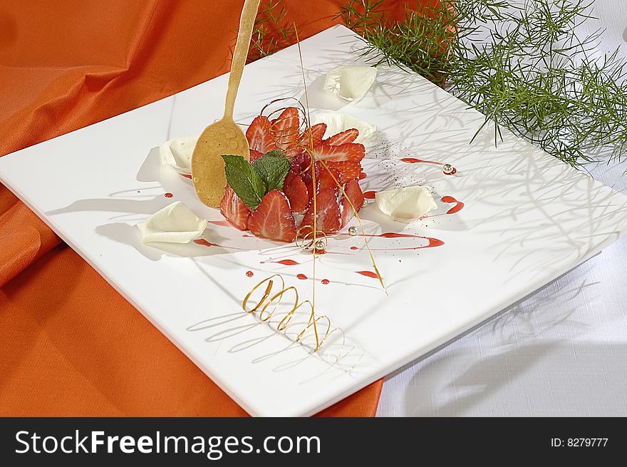 Strawberry dessert, decorated white petals of rose, pearls and mint