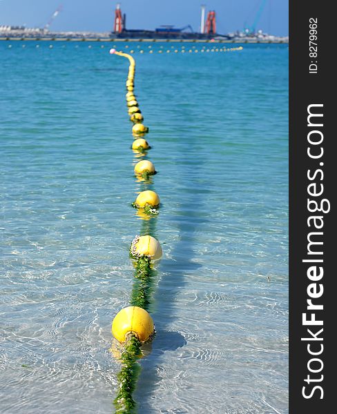 Yellow floats line near unfinished Palm Deira. UAE.