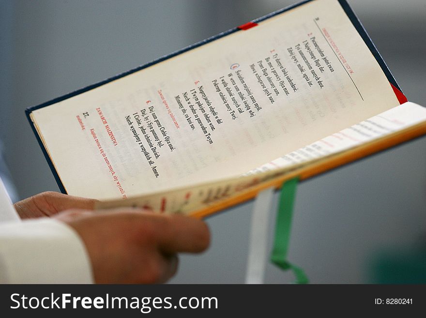 Priest reading open holly bible, wedding in Poland