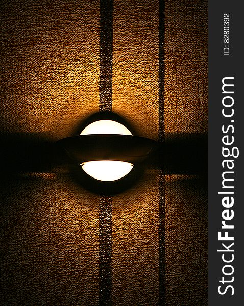 Modern lamp on a brown  wall  with a protuberant structure