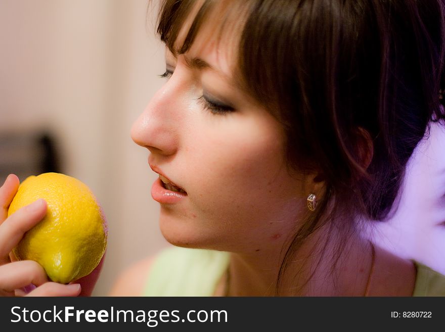 A girl holds in her hand a yellow lemon. Feeling lusciousness. A girl holds in her hand a yellow lemon. Feeling lusciousness