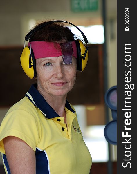 Female competitor at shooting range preparing to shoot