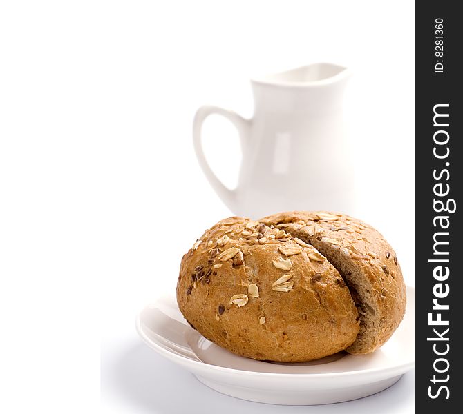 Bread and jug of milk on white background