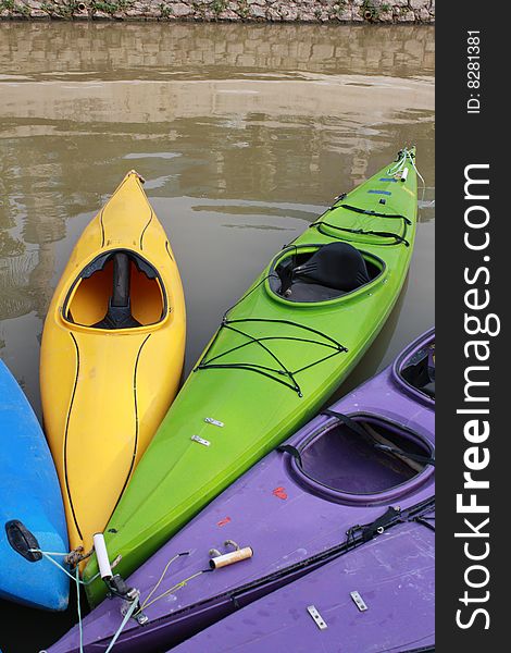 Colourfull kayaks hooked on riverside. Colourfull kayaks hooked on riverside