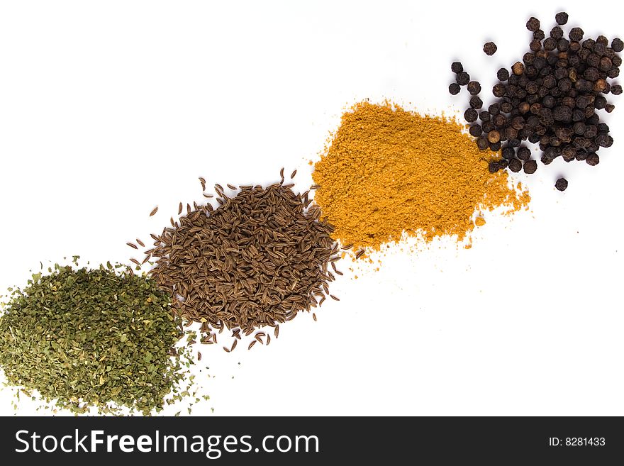 Haps of various spices on white background