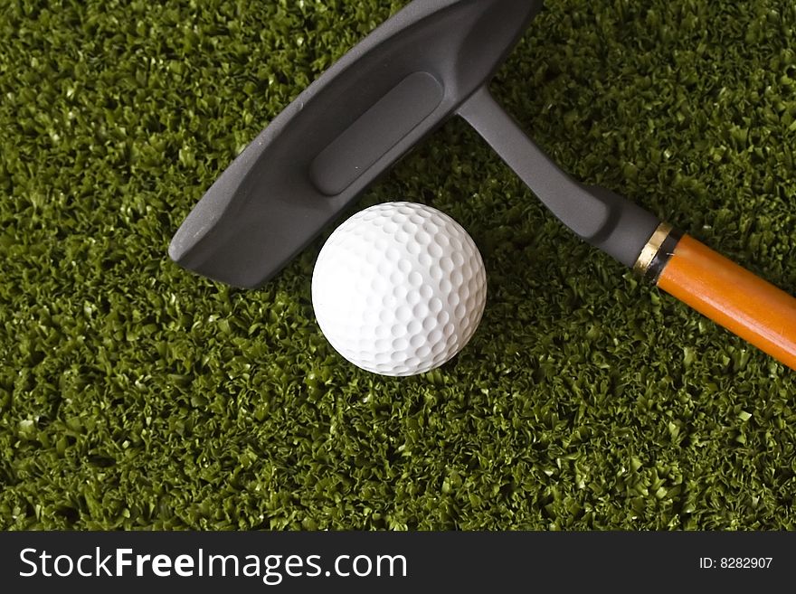 Golf ball and stick on the grass