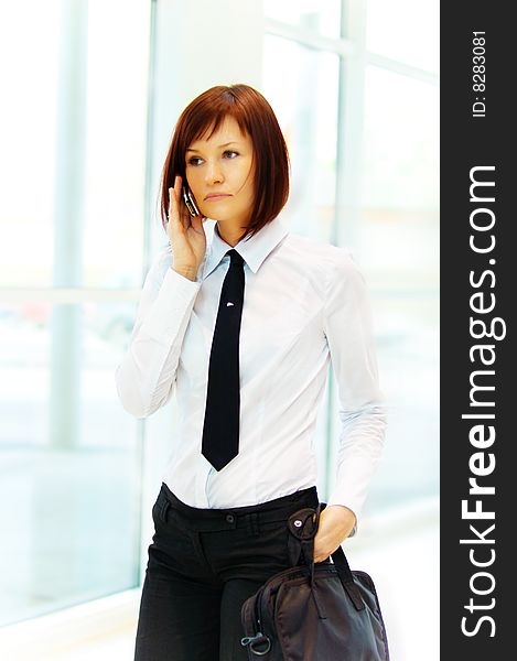 Business woman on the phone, carrying a briefcase with documents. Business woman on the phone, carrying a briefcase with documents