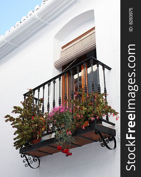 Typical Spanish balcony decorated with potted plants. Typical Spanish balcony decorated with potted plants.