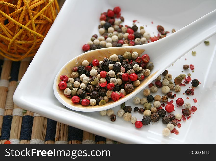 Some colourful pepper seeds on a spoon