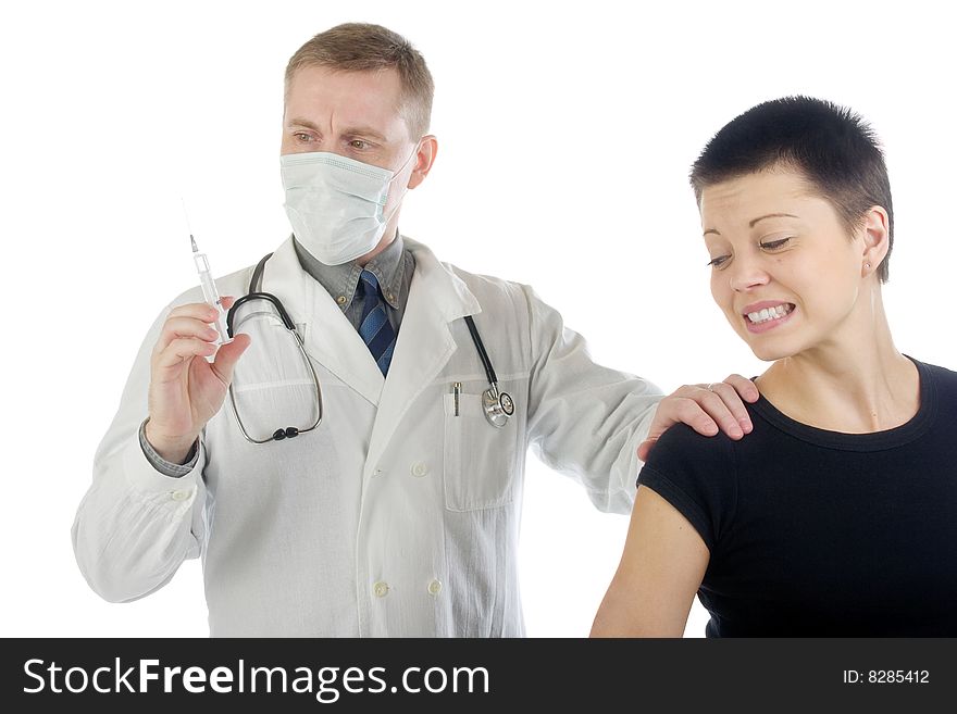 Doctor in gauze mask checks up a syringe while he holds a frightened woman by her shoulder. Doctor in gauze mask checks up a syringe while he holds a frightened woman by her shoulder