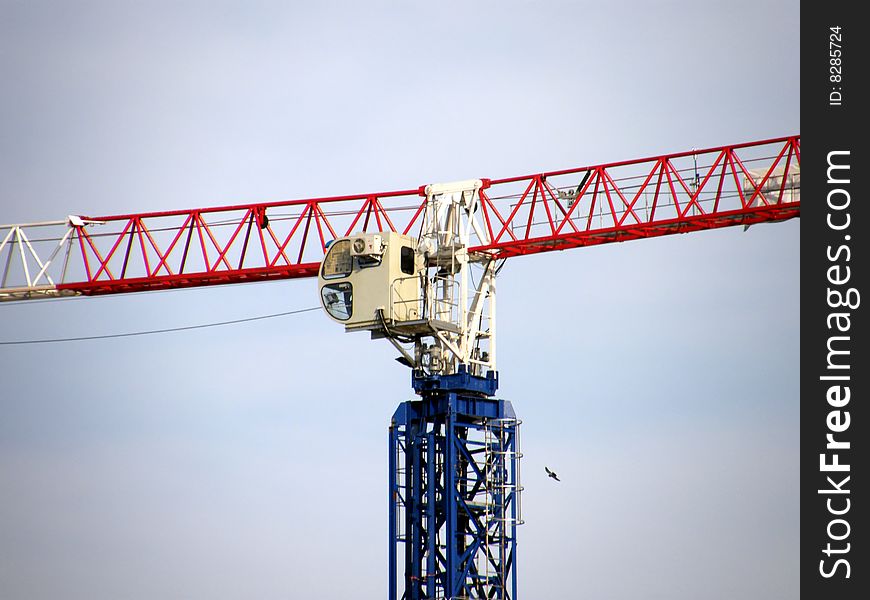 Construction crane at a construction site against the backdrop of blue sky