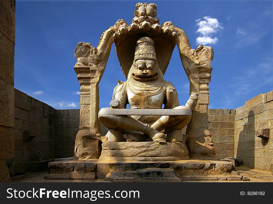 On a photo: Statue of a indian deity in historical park Hampy.