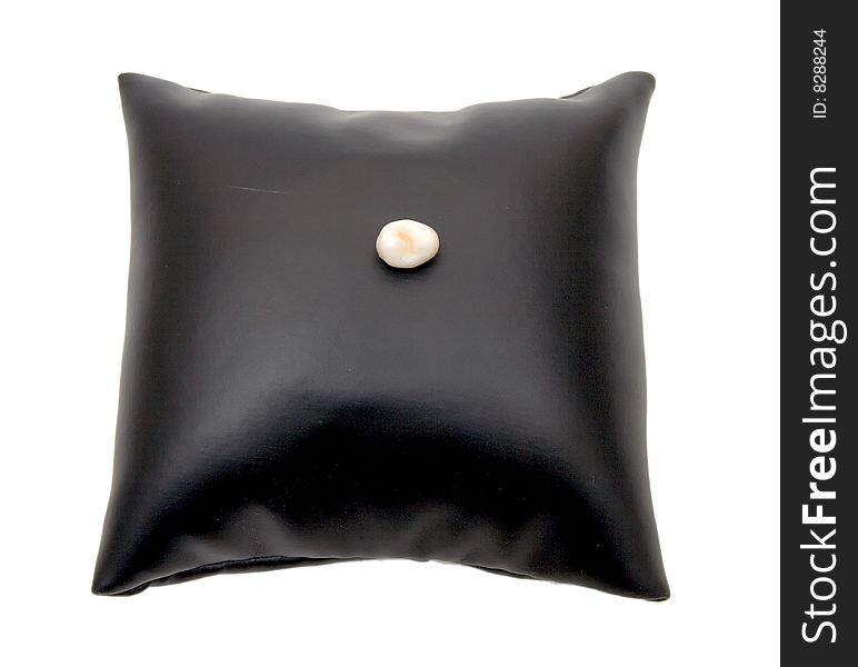 The top / crown of an extracted tooth on a small black pillow. The top / crown of an extracted tooth on a small black pillow