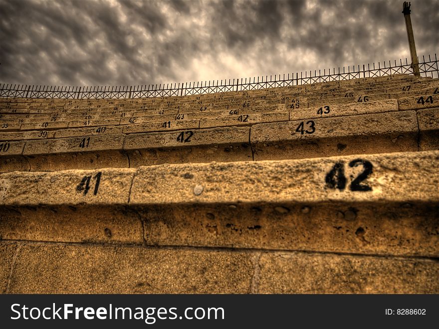 Seat numbers of an authentic ancient colosseum with cloudy dramatic sky