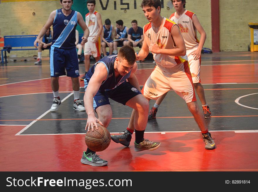 Athlete dribbling ball during basketball on indoor court. Athlete dribbling ball during basketball on indoor court.