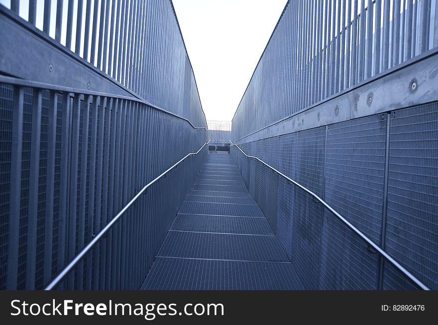 Metal walkway with mesh fencing on sunny day. Metal walkway with mesh fencing on sunny day.