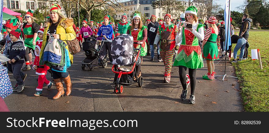 People in elf outfits on street during Christmas parade. People in elf outfits on street during Christmas parade.