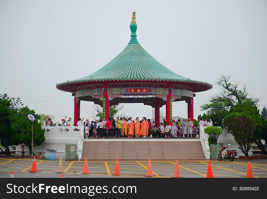 An Asian or Chinese pavilion with people under overcast skies.