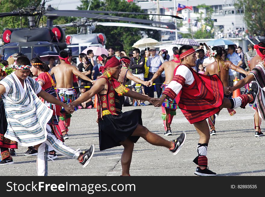 A parade of people dancing native dances in costumes.