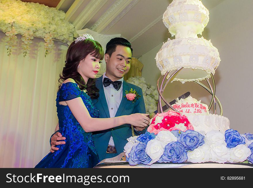 Wedding couple cutting a gigantic wedding cake together. Wedding couple cutting a gigantic wedding cake together.