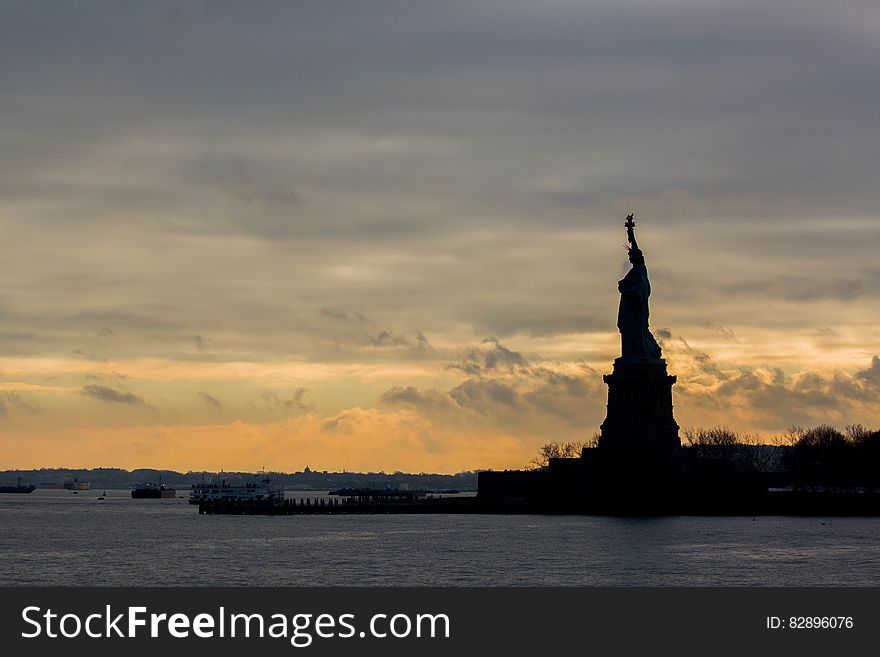 The silhouette of the Statue of Liberty by the sunset. The silhouette of the Statue of Liberty by the sunset.