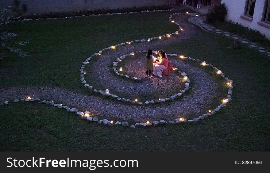 A garden with a path in spiral shape lit by lanterns and candles. A garden with a path in spiral shape lit by lanterns and candles.