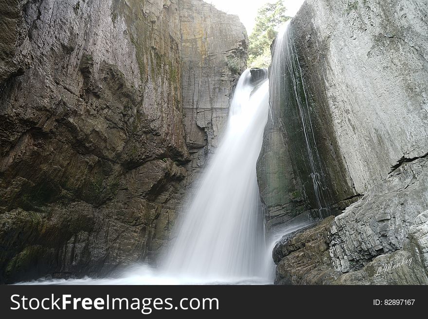 Waterfalls over rocky ridge down steep stone ravine. Waterfalls over rocky ridge down steep stone ravine.