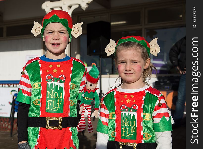 Boy and girl standing outdoors dressed in elf costumes. Boy and girl standing outdoors dressed in elf costumes.