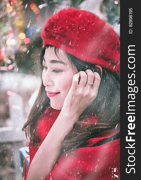 Outdoor winter portrait of Asian woman wearing red had and coat in snow storm. Outdoor winter portrait of Asian woman wearing red had and coat in snow storm.