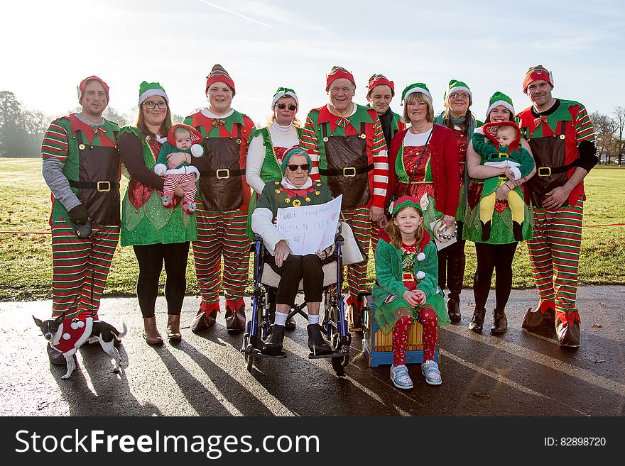 Group of adult men and women with babies and children dressed in elf costumes. Group of adult men and women with babies and children dressed in elf costumes.