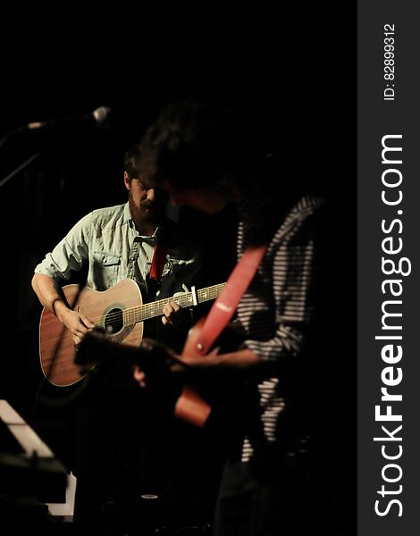 Musicians playing acoustic guitars in concert. Musicians playing acoustic guitars in concert.